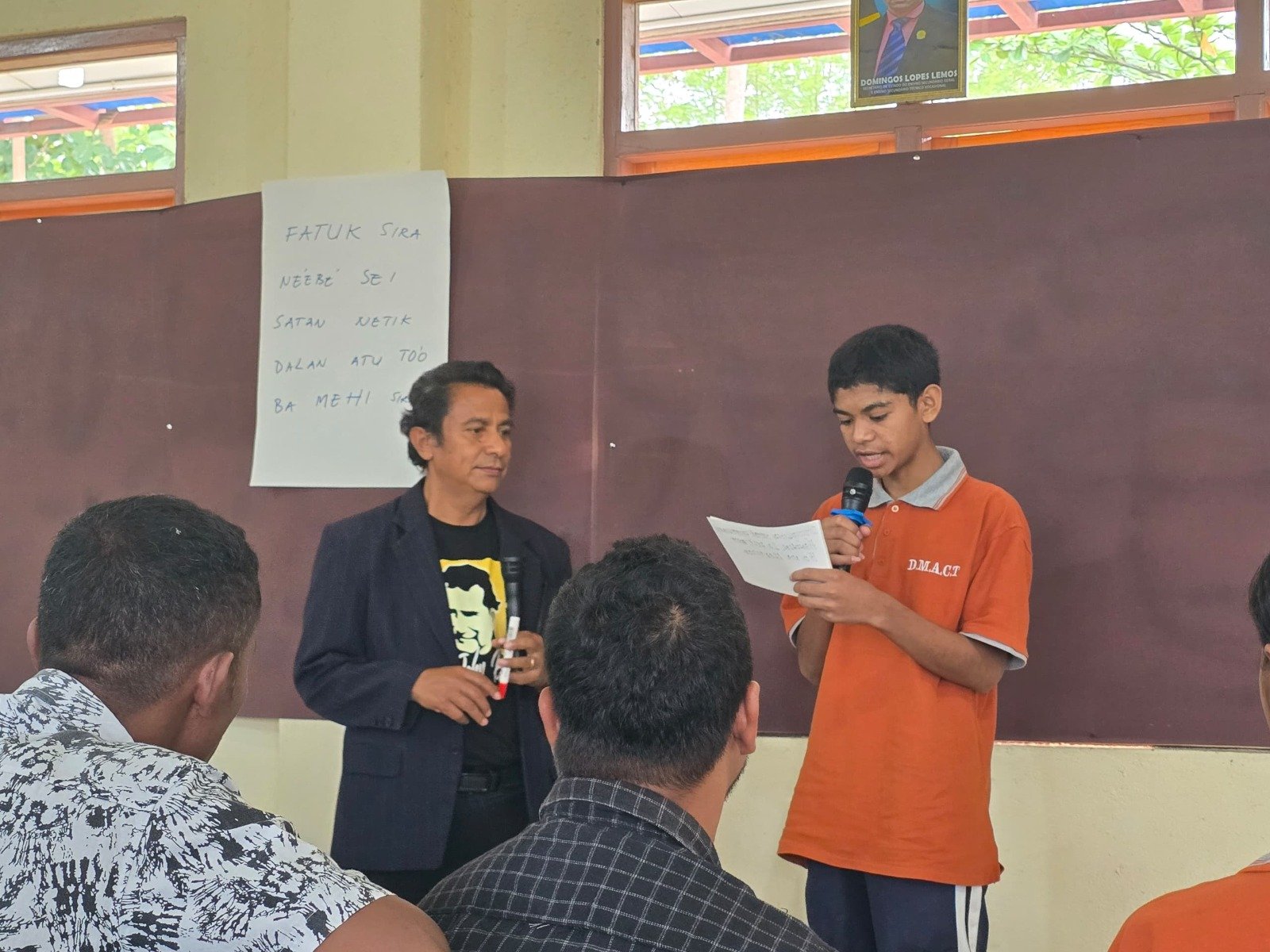 Siswa sedang presentasi memegang mik